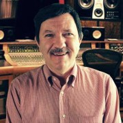 Man with a salt and pepper mustache and dark hairpiece